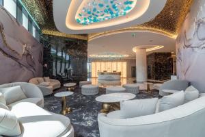 eine Lobby mit Sofas und Tischen in einem Gebäude in der Unterkunft Elania Resort & Spa in Cluj-Napoca