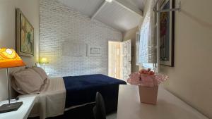 a bedroom with a bed and a desk with a lamp at Casa confortavel, bem equipada com Wi-Fi e garagem in Massaguassu