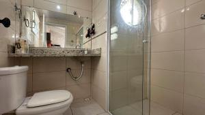 a bathroom with a toilet and a glass shower at Casa confortavel, bem equipada com Wi-Fi e garagem in Massaguassu +20 photos