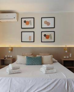 アロヨ・デ・ラ・ミエルにあるEstudio Centrico Irisのベッドルーム1室(壁に3枚の写真が飾られた白い大型ベッド1台付)