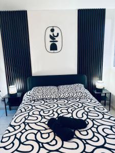 a bedroom with a bed with a black and white comforter at Love Room-Jacuzzy-Beziers in Béziers +5 photos