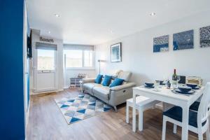 una sala de estar con un sofá y una mesa en Charming Beach Chalet with Balcony & Sea Views, en Pembrokeshire