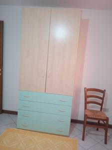 a blue dresser and a chair in a room at Lungomare 2 in Porto Alabe