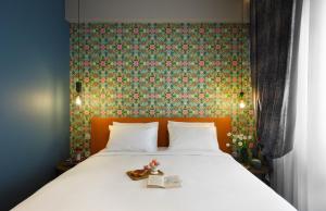 a bed with two books and two teddy bears on it at The Oscar Olympic Hotel in Thessaloniki