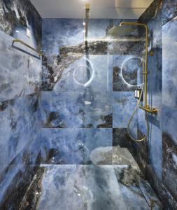 a bathroom with a shower with blue tiles at The Oscar Olympic Hotel in Thessaloniki