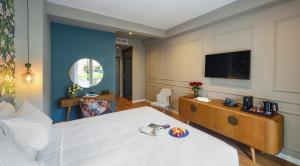 a hotel room with a bed and a flat screen tv at The Oscar Olympic Hotel in Thessaloniki