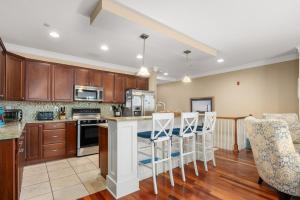 a kitchen with wooden cabinets and a counter with bar stools at CSC3E Afternoon Delight in Kill Devil Hills
