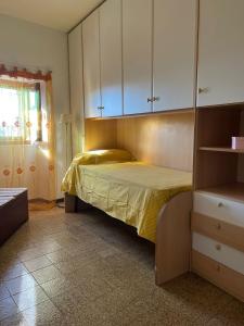 una camera da letto con un letto con armadi bianchi e una finestra di La Casetta nel Borgo a Mezzana