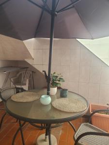 une table avec deux chaises et un parasol dans l'établissement Chambre Marlene, à Lagos
