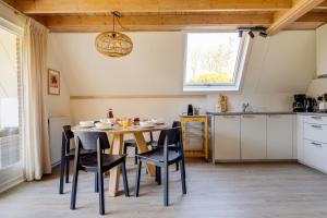 ZwiggelteにあるVelduil I Mooi Huisje met Ruime Tuinのテーブルと椅子のあるキッチンとダイニングルーム