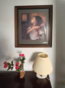 Una imagen de una mujer en una pared con una lámpara y flores. en Upper Northgate street, en Chester