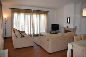 a living room with two couches and a television at Esplendor beiramar refúgio na Praia del Rey B9 in Amoreira