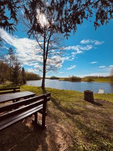 a park bench sitting in front of a lake at Brīvdienu māja Straumēni in Pāle
