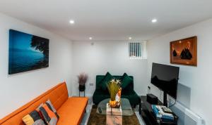 a living room with an orange couch and a piano at Cozy room 1 in Sale