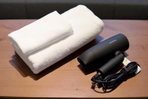 a blow dryer and towels on a table at DAC Susukino in Sapporo