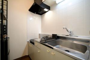a kitchen with a sink and a counter top at DAC Susukino in Sapporo