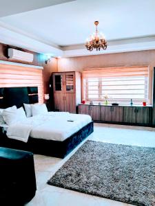 a bedroom with a large bed and a chandelier at Zamin Suites in Abuja