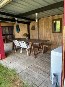 a wooden table and chairs on a patio at Gîte pura vida in Périssac