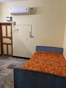 a bed sitting in a room with a door at Srinivasa Homestay in Tiruvannāmalai