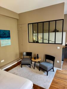 a bedroom with two chairs and a table and a bed at Wisteria in Fontainebleau