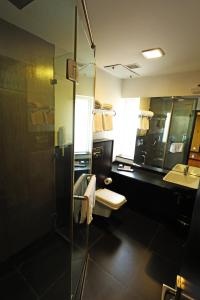 a bathroom with a shower and a toilet and a sink at Purple Brigade, Bangalore in Bengaluru