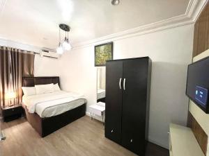 The Aire Flat في لاغوس: غرفة نوم بها سرير وتلفزيون