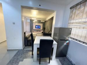 The Aire Flat في لاغوس: مطبخ مع طاولة بيضاء وثلاجة