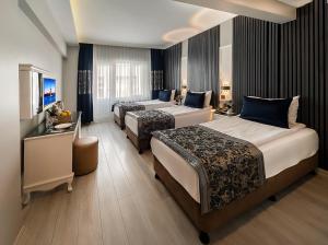 a hotel room with two beds and a television at Beyazit Palace Hotel in Istanbul