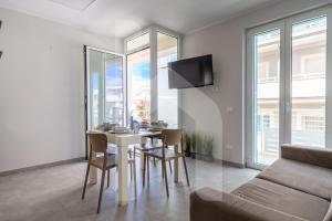ein Wohnzimmer mit Tisch und Stühlen und einer Couch in der Unterkunft Homiday - Stella Del Mare in Alba Adriatica