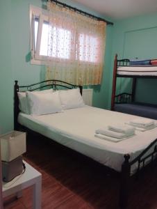 Un dormitorio con una cama con sábanas blancas y una ventana. en Dimi apartment, en Nea Peramos 14 fotos más