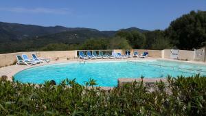 una grande piscina con sedie blu di Maison Alba Rossa 56 a Serra di Ferro