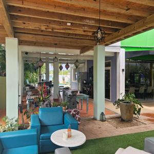 a patio with a blue couch and tables and chairs at Quints Travelers Inn in Willemstad