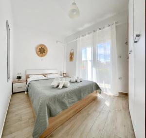 a white bedroom with a large bed with white pillows at Danai Apartment with pool Access in Ofrínion