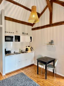 a kitchen with white cabinets and a black table at Wisteria in Fontainebleau