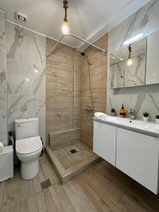 a bathroom with a shower and a toilet and a sink at Danai Apartment with pool Access in Ofrínion
