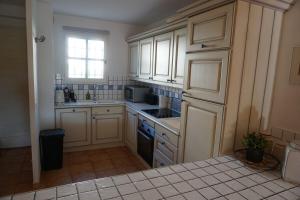 a kitchen with white cabinets and a sink and a window at Maison de village in La Môle