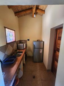 a kitchen with a sink and a refrigerator at El Hornero in Tilcara
