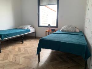 a bedroom with two beds and a window at Maison Benclé in Vaux-sur-Mer