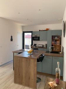 a kitchen with a island in the middle of a room at Maison Benclé in Vaux-sur-Mer +5 photos