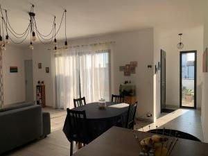 a dining room and living room with a table and chairs at Maison Benclé in Vaux-sur-Mer