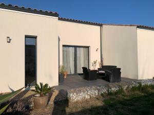 a patio with black chairs and a table at Maison Benclé in Vaux-sur-Mer