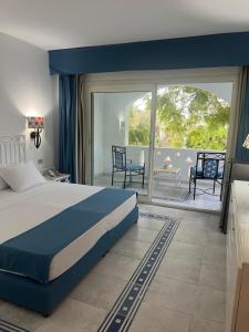 a bedroom with a large bed and a balcony at Domina Coral Bay Aquamarine 1 in Sharm El Sheikh
