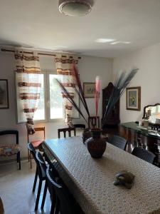 a dining room with a table with a vase on it at A casa di Maria Antonietta in Il Monte