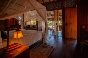 a bedroom with a canopy bed and a porch at Jaguaribe Lodge e Kite in Fortim +74 photos