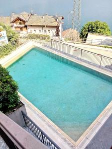 een groot zwembad met blauw water voor een huis bij PERLA 7 by Design Studio in Bellano