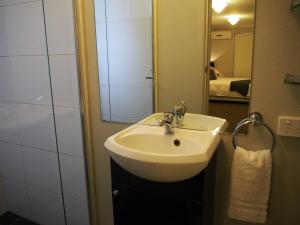 a bathroom with a sink and a mirror at City Quarters on Brewer in Perth +28 photos