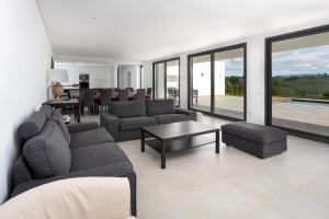 una sala de estar con un sofá y una mesa en Casa Barbónica piscina privada, en Bairro do Lobo