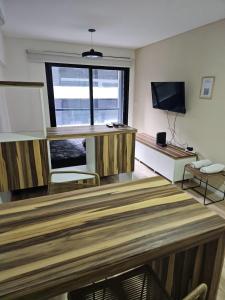 a living room with a large window and a television at Alquiler Temporario Rosario 24 in Rosario