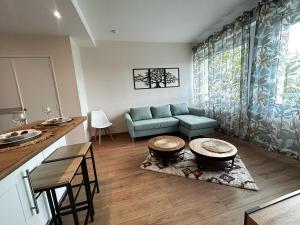 a living room with a blue couch and a table at La Suite Chataîgner, chic et calme in Panazol