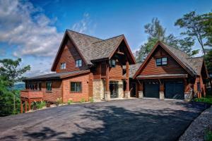 a large wooden house with a driveway at NEW! Villa Panorama 4 Seasons Heated Pool Hot Tub in Mont-Tremblant